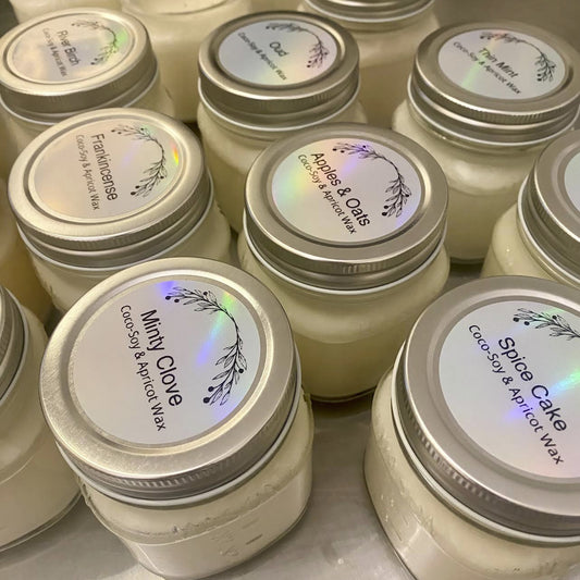 Jars of candles with labels set on a metallic table